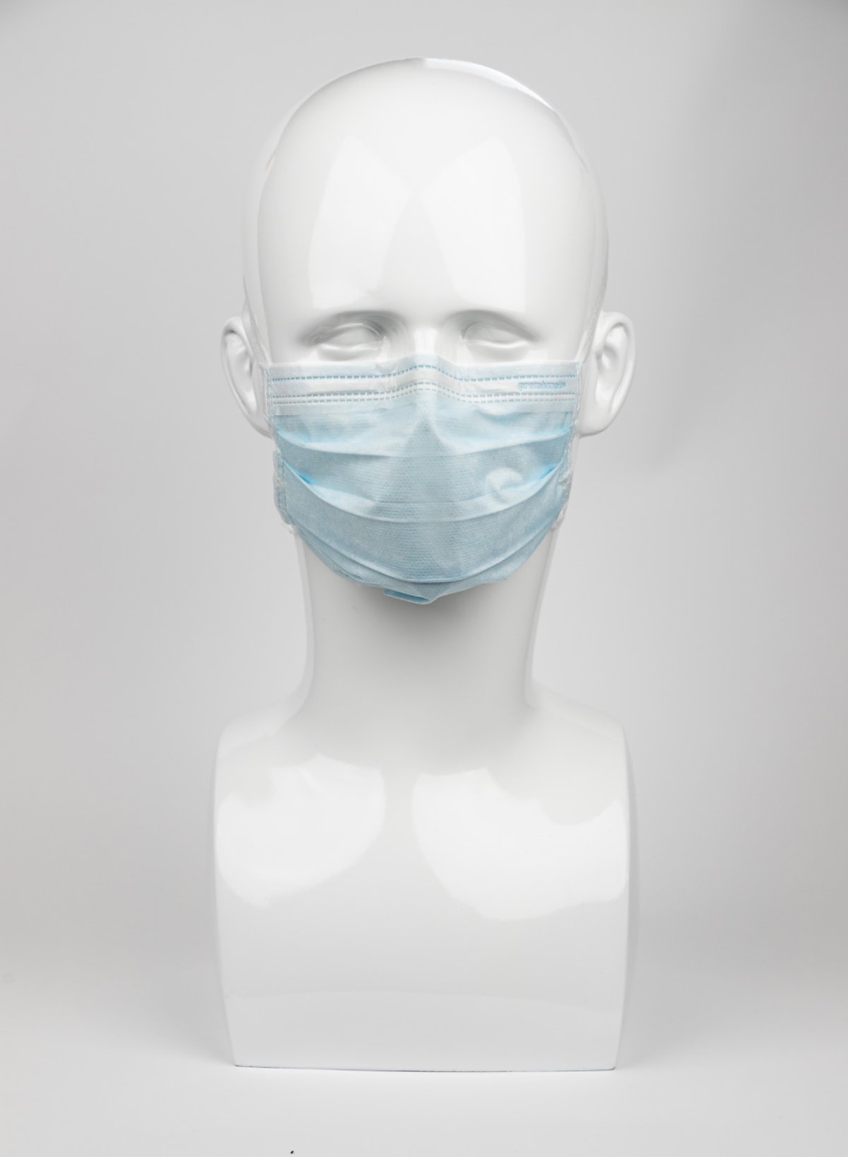Blaue Premium Plus OP-Maske auf einem weißen Modellkopf, mit elastischen Ohrschlaufen und verstellbarem Nasenbügel für komfortablen Sitz und zuverlässigen Schutz.