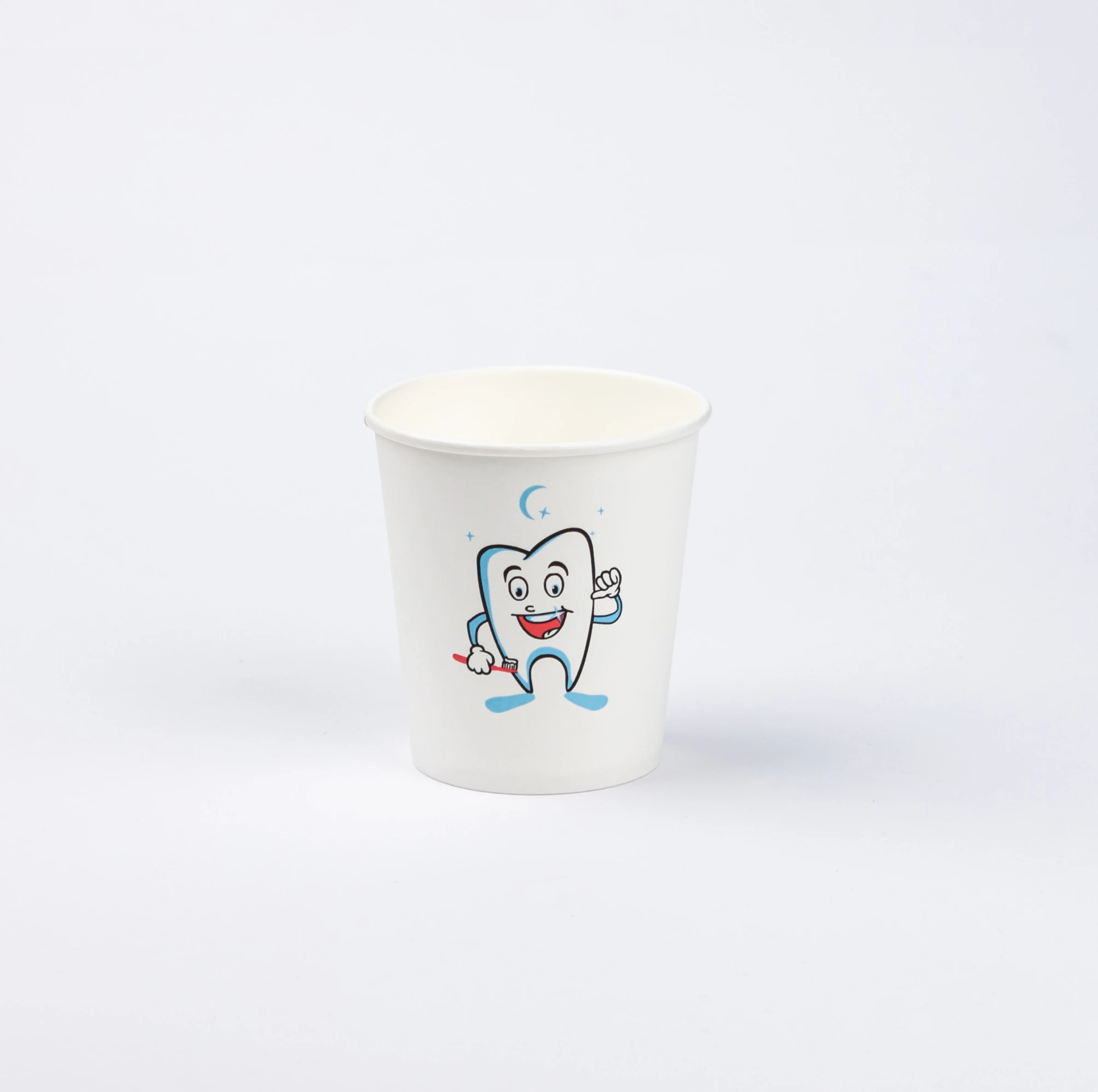 Ein weißer Becher mit lächelndem Zahn-Comic und Mond-Symbol